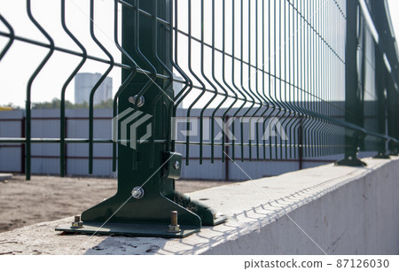 Steel lattice green fence with wire. Fencing. Grid industrial wire fence panels, pvc metal. Installation of sectional fencing. Welded mesh fence. Installation of a grid for fencing the territory. Steel lattice green fence with wire. Fencing. Grid industrial wire fence panels, pvc metal. Installation of sectional fencing. Welded mesh fence. Installation of a grid for fencing the territory. 87126030
