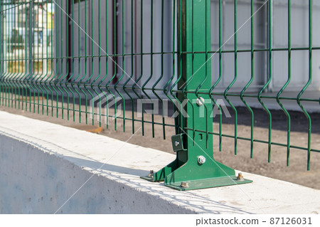 Steel lattice green fence with wire. Fencing. Grid industrial wire fence panels, pvc metal. Installation of sectional fencing. Welded mesh fence. Installation of a grid for fencing the territory. Steel lattice green fence with wire. Fencing. Grid industrial wire fence panels, pvc metal. Installation of sectional fencing. Welded mesh fence. Installation of a grid for fencing the territory. 87126031