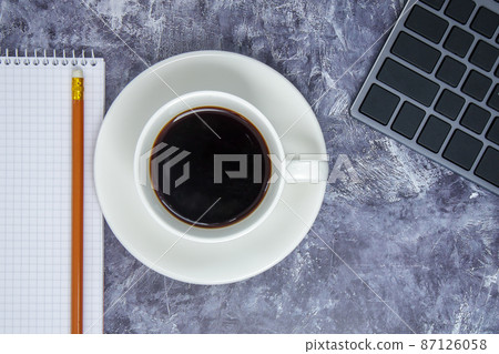 Workspace with keyboard, stationery, pencil, notepad and coffee cup on gray table. Flat lay, office table top view. The concept of business financing and freelancing remote work. Copy space. 87126058