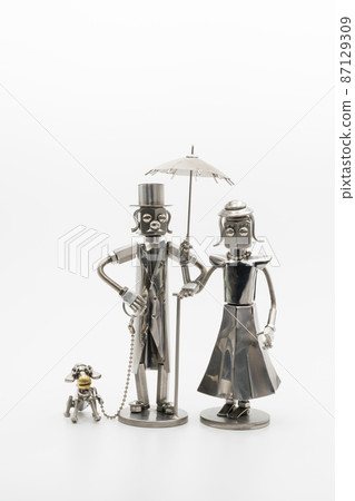 A model of a gentleman and a lady with a dog walking, a metal figure 87129309