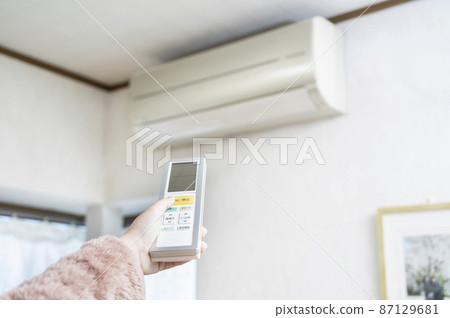 Hand to operate the remote control of the air conditioner Hand to operate the remote control of the air conditioner 87129681