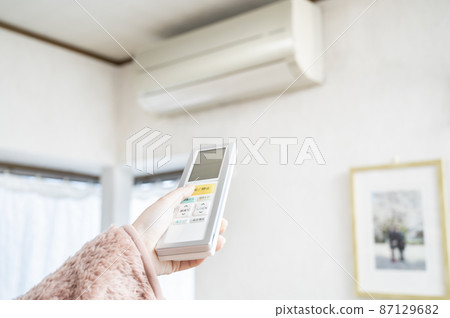 Hand to operate the remote control of the air conditioner Hand to operate the remote control of the air conditioner 87129682