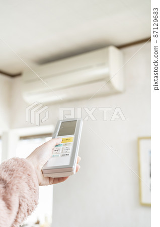 Hand to operate the remote control of the air conditioner Hand to operate the remote control of the air conditioner 87129683