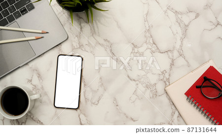 Minimal office worktable with smartphone mockup on marble background. 87131644