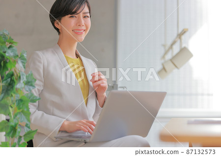Business woman who puts a PC on her lap _ Moves to the left 87132573