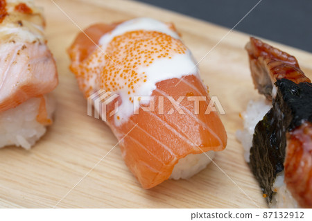 Close - up of sushi salmon in plate on stone table. Close - up of sushi salmon in plate on stone table. 87132912