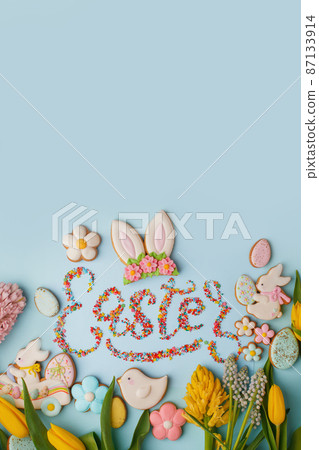 Food Lettering EASTER Colorful easter cookies and flowers tulip on blue background, assortment sweet gifts, seasonal springtime holiday greeting card, creative idea for decor, flyer, invitation Food Lettering EASTER Colorful easter cookies and flowers tulip on blue background, assortment sweet gifts, seasonal springtime holiday greeting card, creative idea for decor, flyer, invitation 87133914