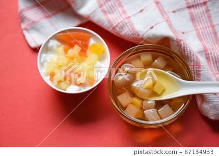 Chinese desserts, milk pudding fruit salad and Mix ginkgo nuts cassava syrup coconut jelly in longan juice on glass bowl, Thai and Chinese longan date soup Asian dessert sweets 87134933