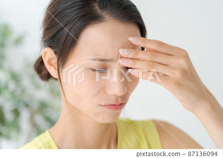 A woman holding her forehead A woman holding her forehead 87136094