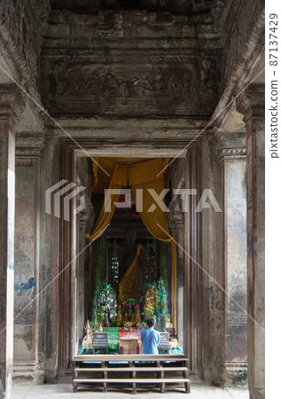 A prayer at Angkor Wat Temple 87137429