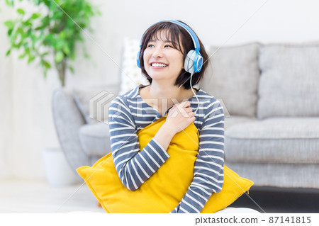 Young woman listening to music on headphones Young woman listening to music on headphones 87141815