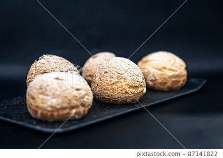 Appetizing Shu cakes on a black background. Appetizing Shu cakes on a black background. 87141822