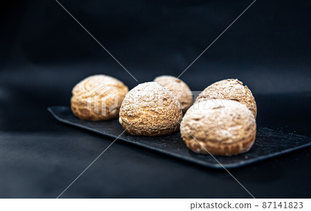 Appetizing Shu cakes on a black background. Appetizing Shu cakes on a black background. 87141823