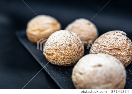 Appetizing Shu cakes on a black background. Appetizing Shu cakes on a black background. 87141824
