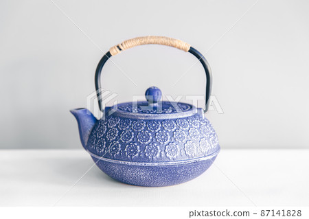 Blue cast iron teapot on a white background. Blue cast iron teapot on a white background. 87141828