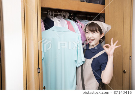 Female staff cleaning up the closet 87143416