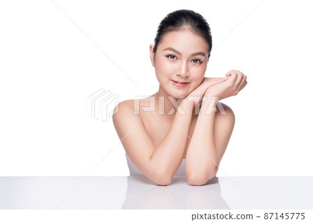 Facial treatment. Beautiful Young Asian Woman with Clean Fresh Skin touch her face . 87145775