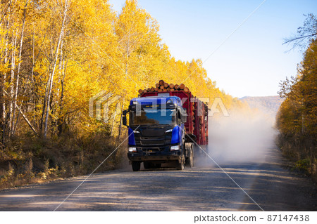 Blue logging truck on forest road in autumn Blue logging truck on forest road in autumn 87147438