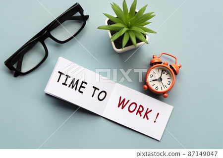 Time to work on notepad with alarm clock show eight o'clock morning time. 87149047