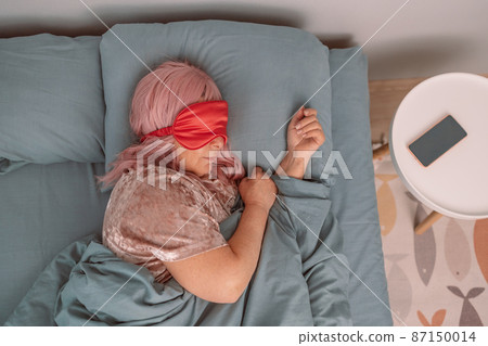 Sweet Dreams. Beautiful caucasian woman in eye mask sleeping in bed early in morning. People, relax and comfort Flat lay 87150014
