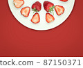 Top view of strawberry in a half plate on isolated red background with copy space 87150371
