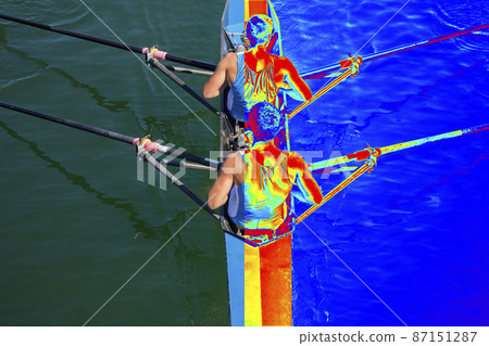 Real and Thermal image of two rowers in a boat, rowing on the tranquil lake 87151287