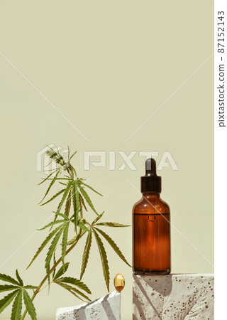 CBD oil in bottle on geometric stand with leaf marijuana CBD oil in bottle on geometric stand with leaf marijuana 87152143