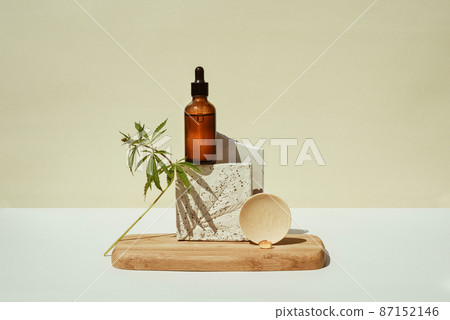 CBD oil in bottle, cannabis bush, hemp on geometric podium 87152146