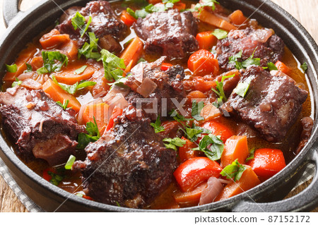 Beef tail oxtail stew cooked in traditional spanish food rabo de toro closeup on a pot on the table. Horizontal Beef tail oxtail stew cooked in traditional spanish food rabo de toro closeup on a pot on the table. Horizontal 87152172