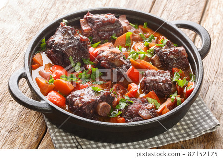Traditional spanish dish slow cooked oxtail in red wine sauce with rabo de toro closeup on a pot on the table. Horizontal Traditional spanish dish slow cooked oxtail in red wine sauce with rabo de toro closeup on a pot on the table. Horizontal 87152175