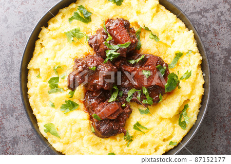 Oxtail rabada traditional dish of Brazilian cuisine closeup on plate on the table. Horizontal top view Oxtail rabada traditional dish of Brazilian cuisine closeup on plate on the table. Horizontal top view 87152177