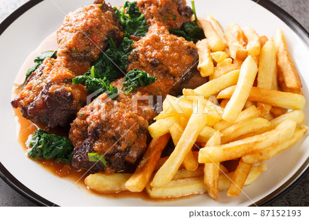 Meat for bull tail stew Rabo de toro served with french fries on white plate. Horizontal Meat for bull tail stew Rabo de toro served with french fries on white plate. Horizontal 87152193