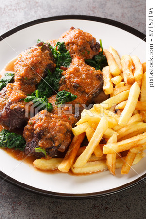 Spanish Bull Tail Stew Rabo De Toro served with french fry closeup in the plate. Vertical Spanish Bull Tail Stew Rabo De Toro served with french fry closeup in the plate. Vertical 87152195