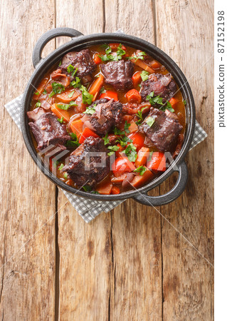 Spanish Bull Tail Stew Rabo De Toro closeup on a pot on the table. Vertical top view Spanish Bull Tail Stew Rabo De Toro closeup on a pot on the table. Vertical top view 87152198