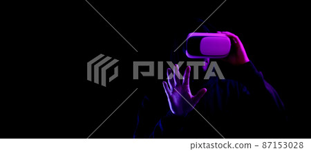 Vr helmet virtual reality. Model young in digital glasses for virtual reality technology isolated on dark neon background. Augmented reality, game, future technology concept. VR. Vr helmet virtual reality. Model young in digital glasses for virtual reality technology isolated on dark neon background. Augmented reality, game, future technology concept. VR. 87153028