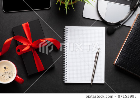 Gift box on office desk table and blank notepad 87153993