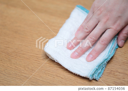Housewife's hand wiping the table with a towel 87154036