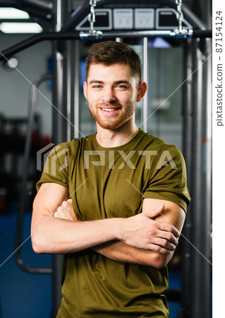 Sportive fit man portrait in gym interior Sportive fit man portrait in gym interior 87154124
