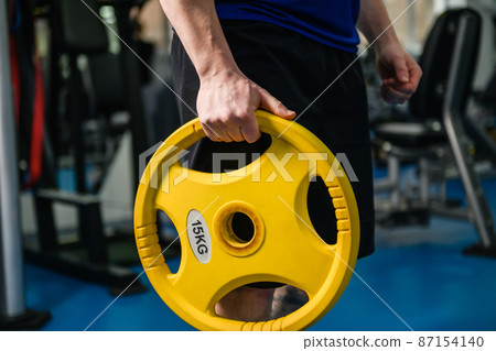 Muscular man hands with gym dumbbell weight 87154140