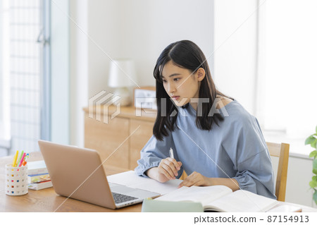 一邊看電腦一邊學習的女孩高中初中生 87154913