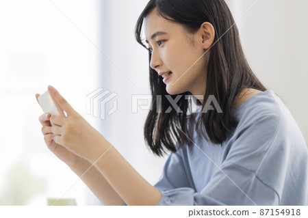 Girl studying while looking at a smartphone High school junior high school student 87154918
