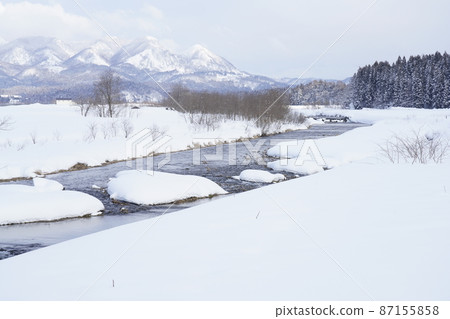 清澈的小溪在雪中順暢流動 清澈的小溪在雪中順暢流動 87155858