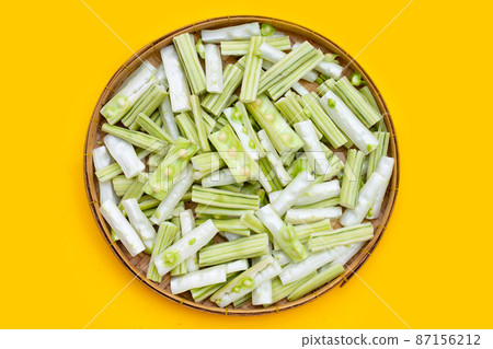 Moringa oleifera cut in pieces in bamboo weave plate on yellow background. Moringa oleifera cut in pieces in bamboo weave plate on yellow background. 87156212