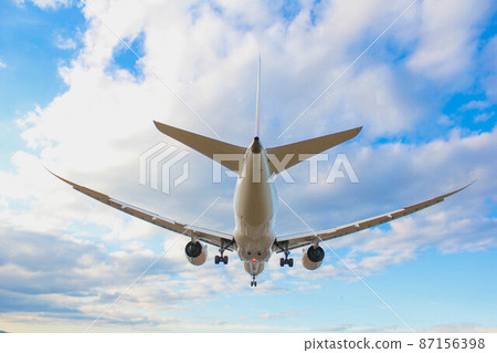Passenger plane "Osaka Airport" flying in the blue sky Passenger plane "Osaka Airport" flying in the blue sky 87156398