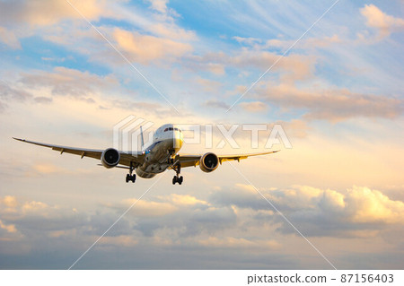 夕陽染紅的客機“大阪機場”在天空飛翔 87156403