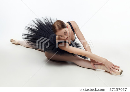 elegant ballerina made a deflection. photo shoots in the studio on a white background elegant ballerina made a deflection. photo shoots in the studio on a white background 87157057