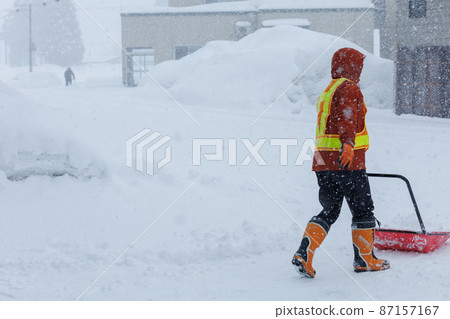 A man who is working on snow gathering in winter Snow scoop 87157167