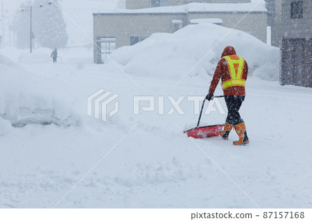 A man who is working on snow gathering in winter Snow scoop 87157168