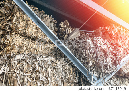 Stacks of prepared waste paper in a hangar for further processing Stacks of prepared waste paper in a hangar for further processing 87158049