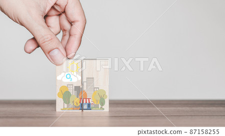 Hand holding with O3 chemical formula icon on wooden cube block with abstract cartoon city. Green office and urban concept. Hand holding with O3 chemical formula icon on wooden cube block with abstract cartoon city. Green office and urban concept. 87158255